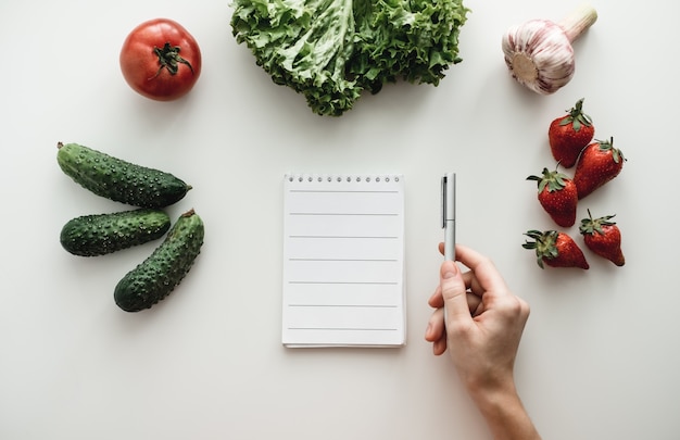 Taccuino con penna e verdure su un tavolo