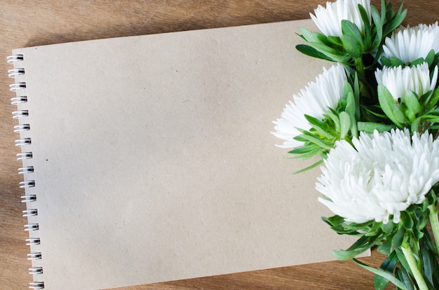 Taccuino marrone in bianco con i fiori di autunno.