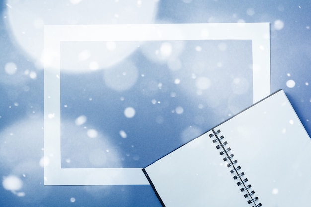 Taccuino o album da disegno con cornice in carta su sfondo blu classico con effetto neve