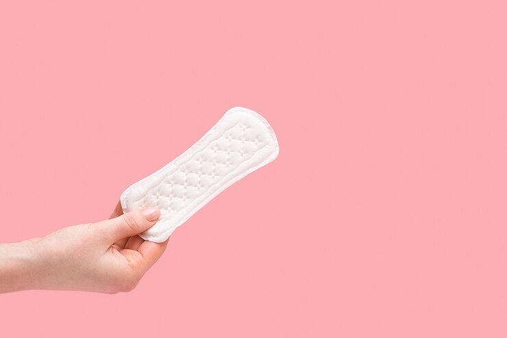 Taccuino quotidiano delle donne in mano su una superficie rosa
