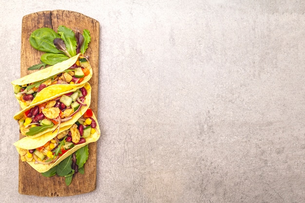 Taco messicano con carne di pollo, fagioli rossi e verdure fresche