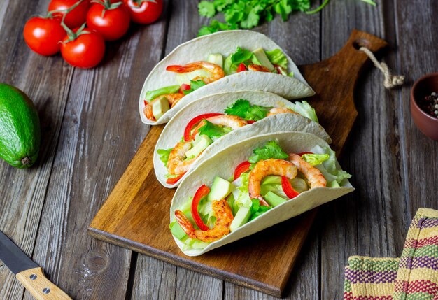 Tacos con gamberi, avocado e insalata. Cibo messicano.