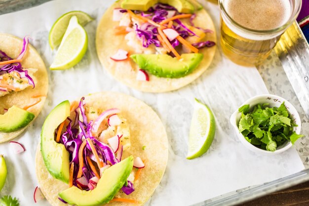 Tacos di pesce fresco con merluzzo e cavolo viola su tortillas di mais bianco.