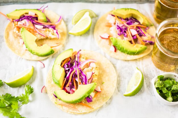 Tacos di pesce fresco con merluzzo e cavolo viola su tortillas di mais bianco.