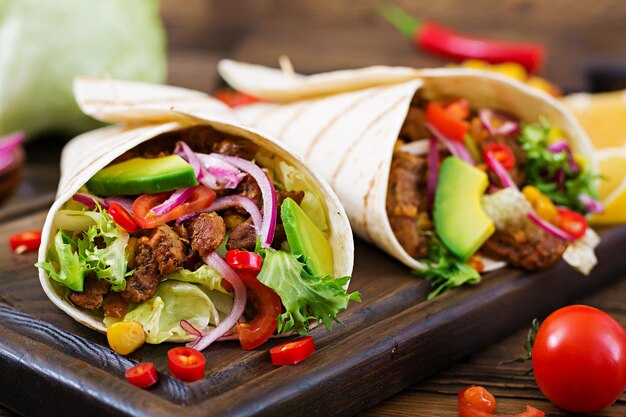 Tacos messicani con carne di manzo in salsa di pomodoro e salsa di avocado