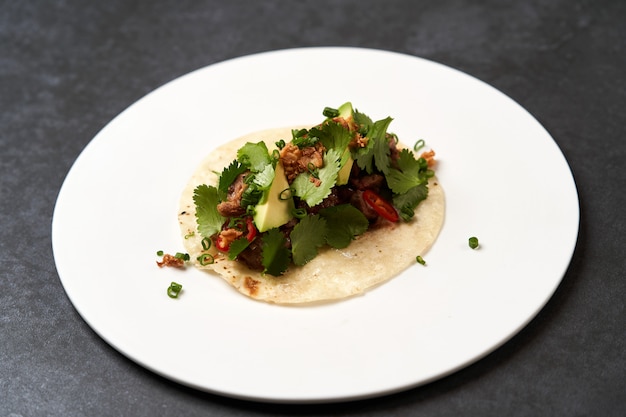 Tacos messicani con carne di manzo, pomodori, avocado, peperoncino e cipolla
