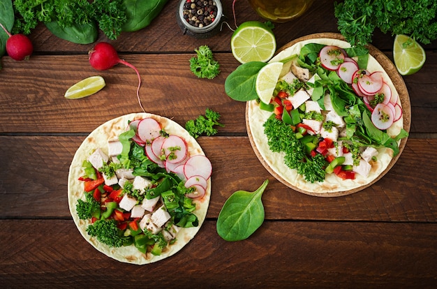 Tacos messicani sani con petto di pollo bollito, spinaci, ravanelli e paprika.