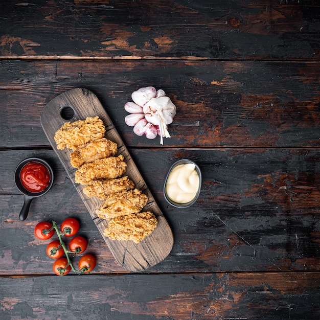 Tagli di ali di pollo impanate fritte piccanti sul tavolo di legno scuro, piatto lay ,.