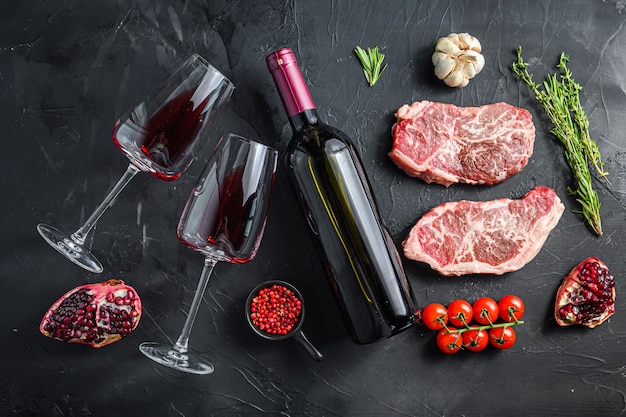 Tagli di bistecca con lama superiore biologica, con bottiglia di vino rosso e bicchieri