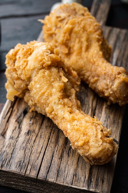 Tagli di pollo fritto croccante sul vecchio tavolo in legno scuro.