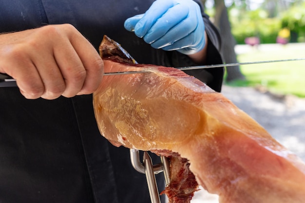 Tagliaprosciutto professionale che taglia un prosciutto iberico in un matrimonio evento di celebrazione