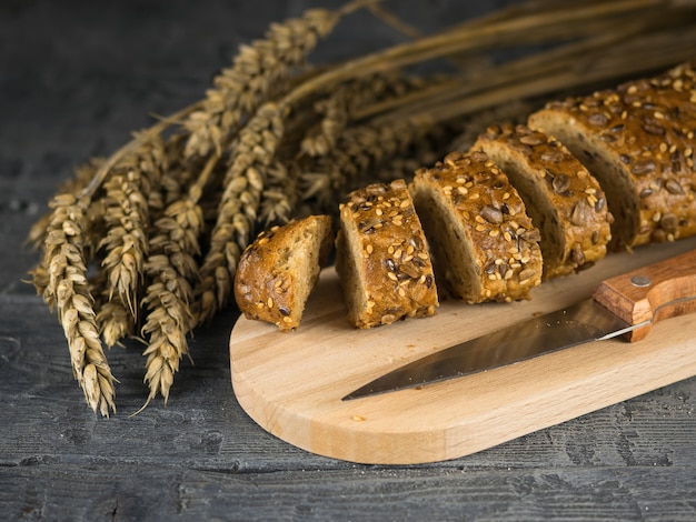 Tagliare a fette di baguette su un tagliere e coltello su un tavolo di legno