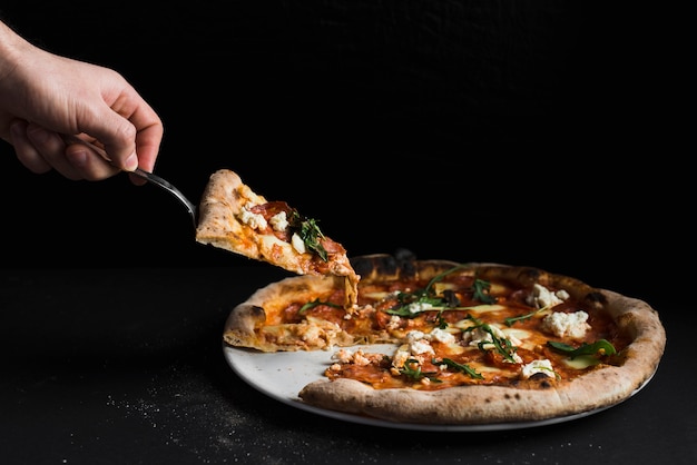 Tagliare a mano prendendo una fetta di pizza