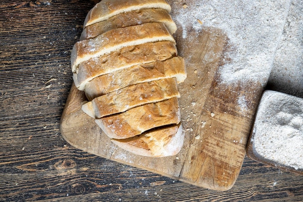 Tagliare a pezzi il pane fresco mentre si cuoce con il pane il pane viene tagliato a fettine