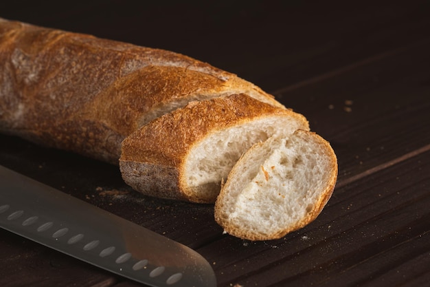 Tagliare a pezzi la pagnotta di pane fresco Fette di baguette francese e coltello da cucina Pane integrale