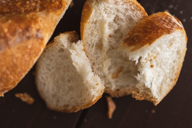 Tagliare a pezzi la pagnotta fresca di pane poroso di grano Fette di baguette francese Foto del primo piano Pane di grano