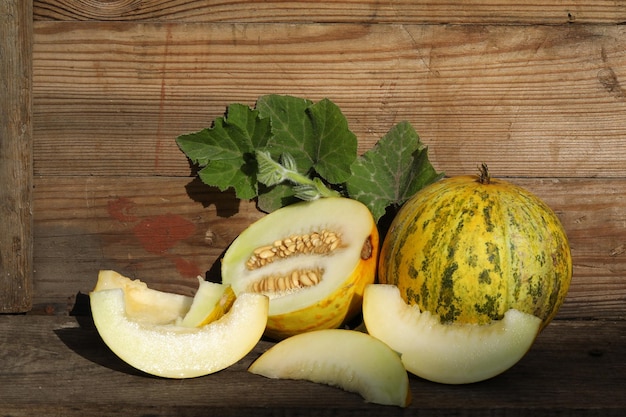 tagliare il melone giallo sullo sfondo di legno vintage