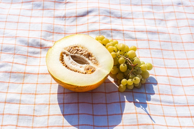 Tagliare l'uva di melone giallo sulla tovaglia Vista dall'alto piatto