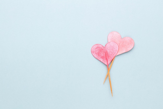 Tagliare la carta a forma di cuore, mettere su uno sfondo pastello. Concetti di San Valentino