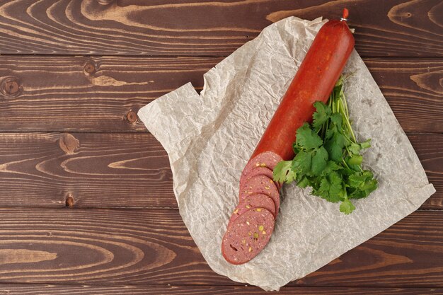 Tagliare la salsiccia di carne sulla fine di legno marrone su