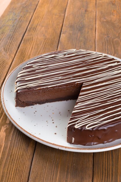 Tagliare la torta al cioccolato sulla piastra sulla tavola di legno