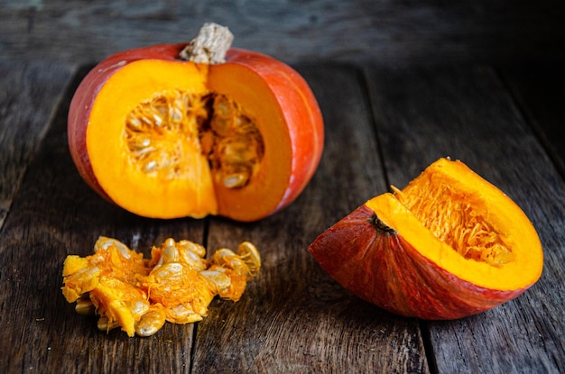 Tagliare la zucca e i suoi semi su assi di legno.