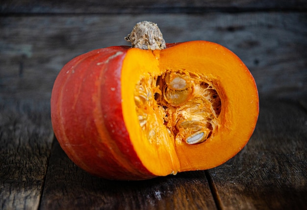 Tagliare la zucca su un tavolo di legno. Cucinare in cucina.