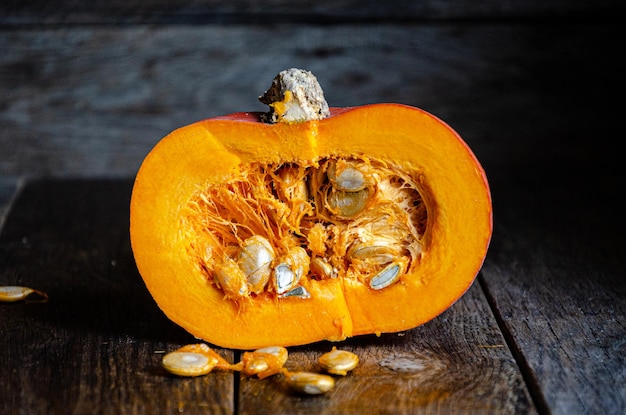 Tagliare la zucca su un tavolo di legno. Cucinare in cucina.