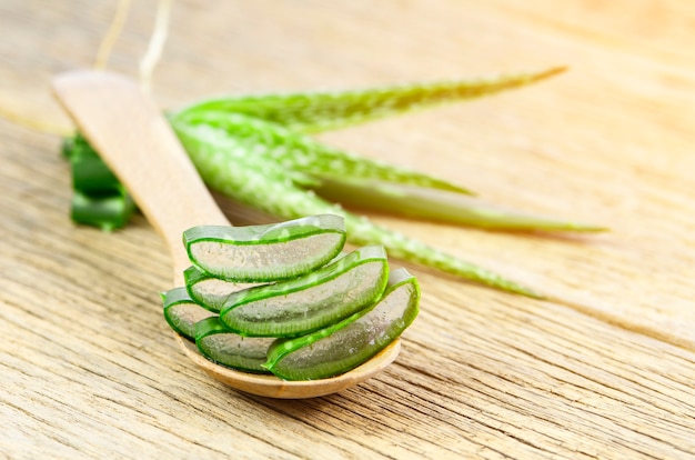 Tagliare le foglie di aloe vera in un cucchiaio di legno.