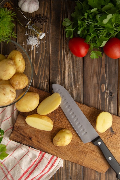 tagliare le patate novelle su una tavola con un coltello ingredienti per il pranzo