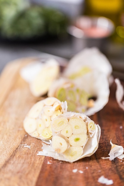 Tagliare le teste d'aglio per preparare la crema di aglio arrosto.