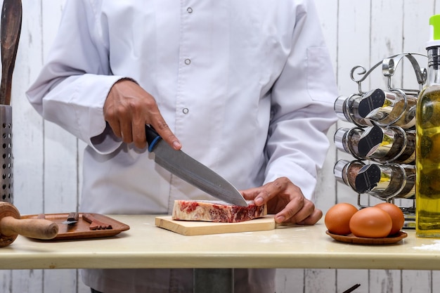 Tagliare succosa bistecca di manzo con le mani dello chef