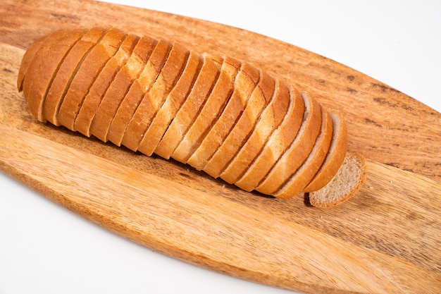 Tagliata a pezzi di pane su un tagliere di legno. prodotto di farina. forno. Ricetta fatta in casa per l'impasto.
