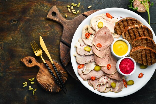 Tagliata di carne affumicata e salame con salsa su un piatto bianco Vista dall'alto