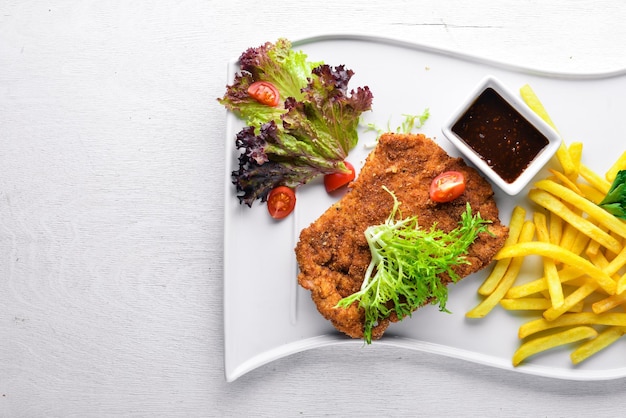 Tagliata di maiale con verdure fresche Su uno sfondo di legno Vista dall'alto Spazio libero per il testo