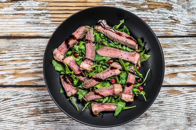 Tagliata di manzo alla griglia con insalata di foglie di rucola.