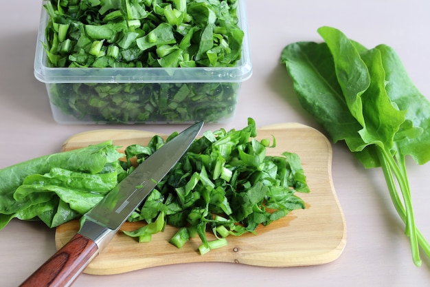 Tagliata di verdure a bordo con coltello e foglie fresche