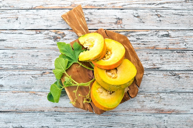 Tagliata di zucca con fette su una tavola di legno Verdure fresche su un tavolo di legno bianco Spazio libero per il testo Vista dall'alto