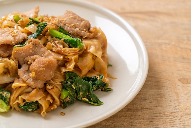 Tagliatella di riso in padella con salsa di soia nera e carne di maiale e cavolo nero