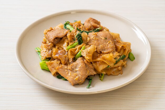 Tagliatella di riso in padella con salsa di soia nera e carne di maiale e cavolo nero