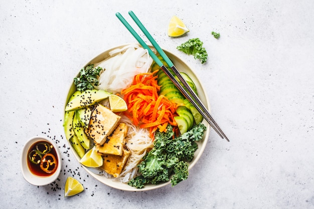 Tagliatella di riso vietnamita con l&#39;insalata arrostita delle verdure dei peperoncini rossi e del tofu in ciotola bianca, vista superiore.