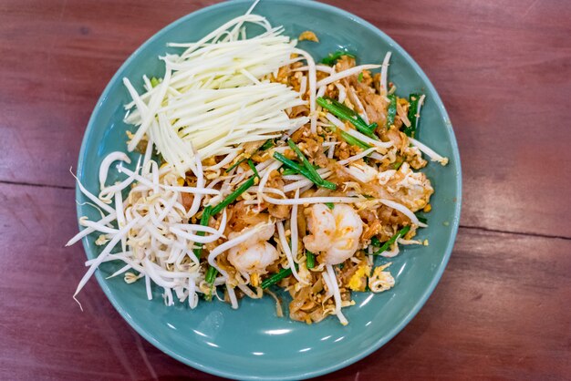 Tagliatella fritta in stile Thai con gamberi "Pad Thai" su un tavolo di legno