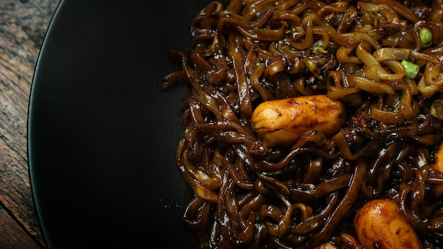 Tagliatella istantanea coreana in banda nera sulla tavola di legno per il contenuto alimentare.