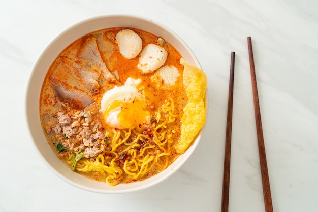 tagliatelle all'uovo con maiale e polpette in zuppa piccante o Tom Yum Noodles in stile asiatico