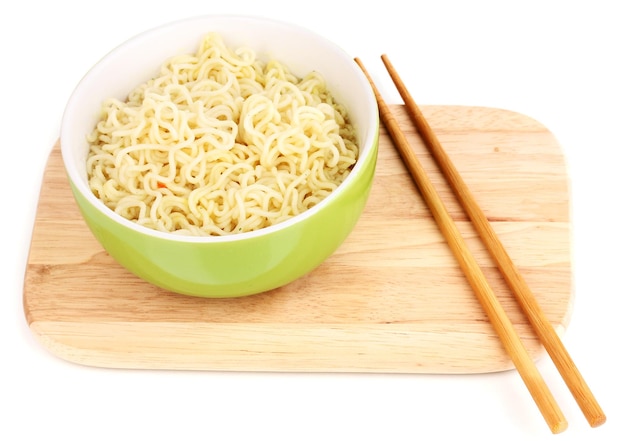 Tagliatelle asiatiche in una ciotola su tavola di legno isolata su bianco