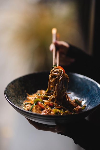 Tagliatelle con frutti di mare e verdure su sfondo scuro. cibo asiatico