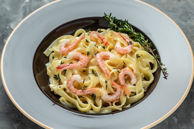 Tagliatelle con gamberi, besciamella e timo. Fettuccine di pasta italiana. Cibo italiano, vista dall'alto.