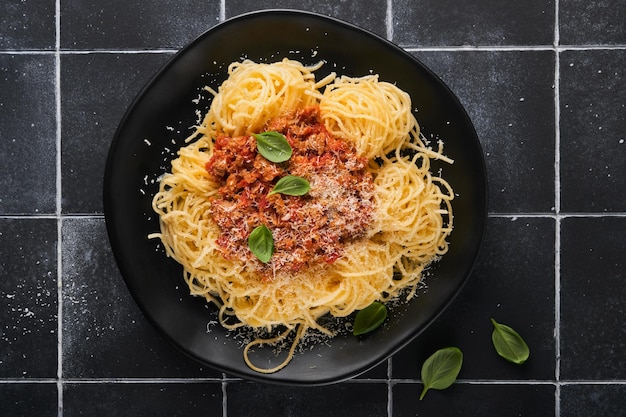 Tagliatelle con polpette in salsa di pomodoro basilico e parmigiano su pietra nera o sfondo di cemento Piatto e cucina tradizionali italiani Vista dall'alto con spazio per la copia