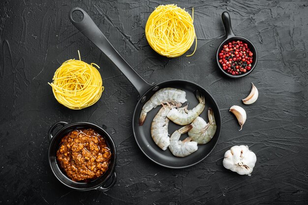 Tagliatelle con set di ingredienti di pesce, su pietra nera, vista dall'alto laici piatta