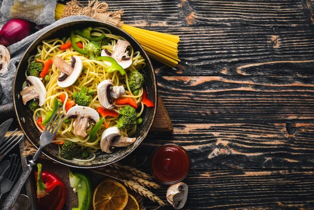 Tagliatelle con verdure in padella Cucina asiatica Pasta Vista dall'alto Spazio libero su sfondo di legno